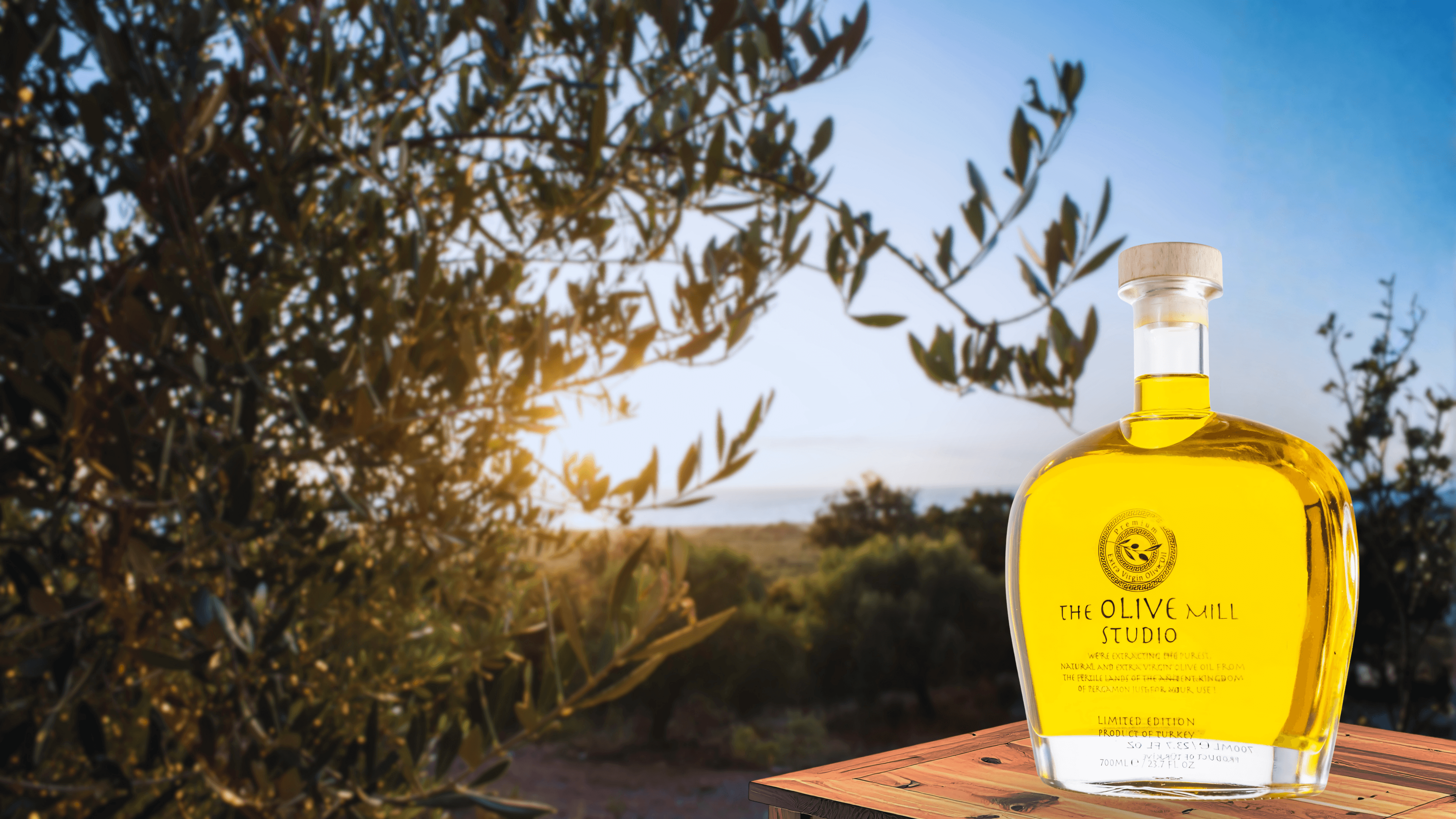 Altın saatte zeytinlik ve The Olive Mill Studio şişesi